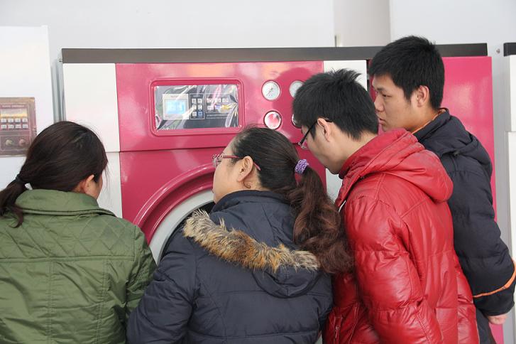 UCC洗衣工作人員在為干洗店加盟商講解干洗設(shè)備知識